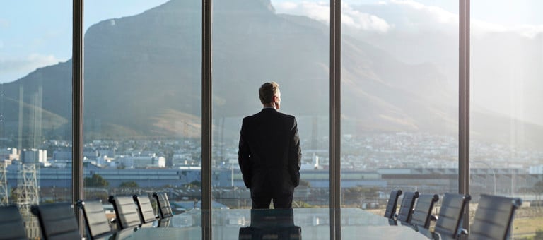 Businessman in a boardroom looking out