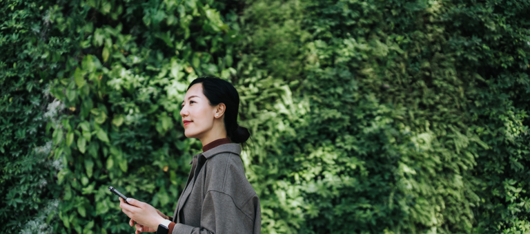 Business woman on phone in front of trees