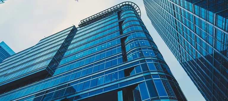 Looking up towards modern glass-fronted buildings