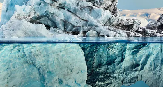 A large iceberg with reflection in a calm blue sea