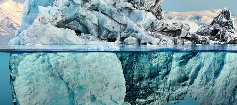 A large iceberg with reflection in a calm blue sea