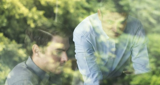 Two people looking at a hidden-from-view screen with trees in the background