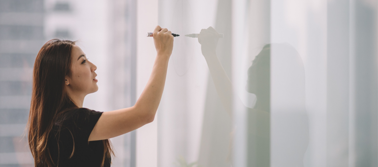 Young woman writing on whiteboard