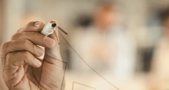 A man drawing a graph on a transparent wall