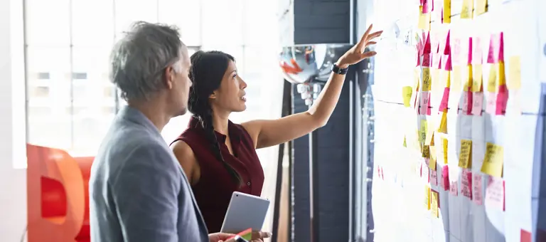 Workplace collaboration man and woman whiteboard