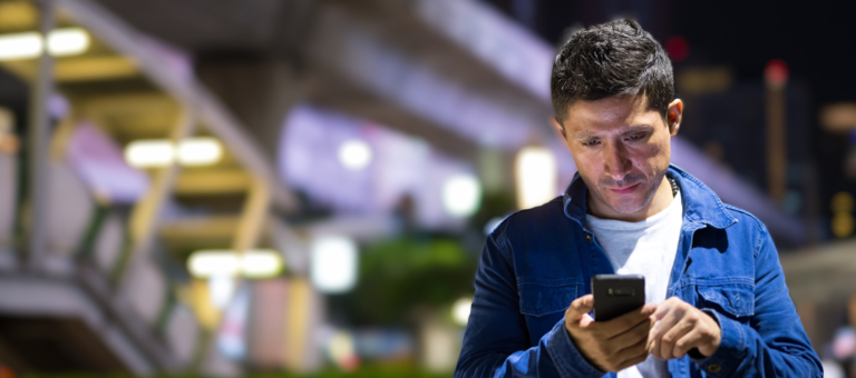 Man looking at his smartphone on the street
