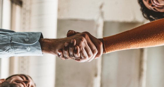 A view from below of two people shaking hands