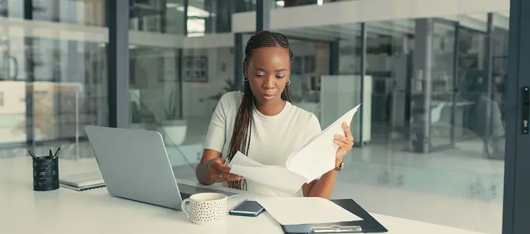 A woman at her office desk looking at reports