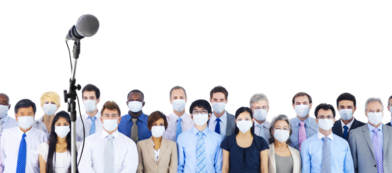 A microphone on a stand in front of professionals wearing facemasks