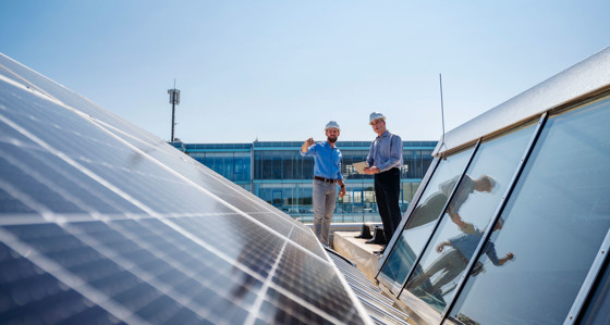 Two engineers inspecting a solar panel