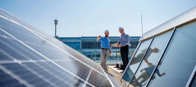 Two engineers inspecting a solar panel