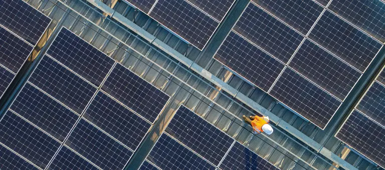 Aerial view of Engineers working at solar panels roof