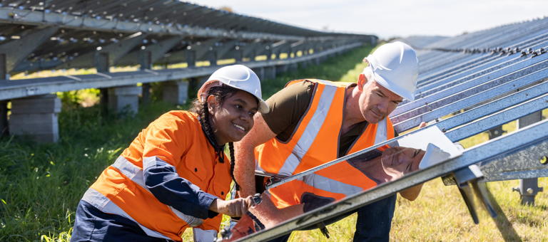 Senior Engineer and Apprentice Working Together On Solar Farm Installation