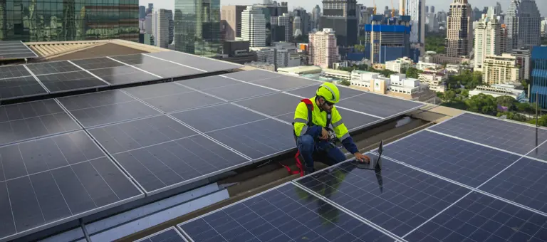 solar panel electrician working on solar panels on building