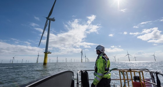 Worker on a boat inspecting an offshore wind farm