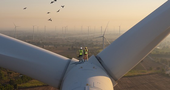 Workers standing on a wind turbine