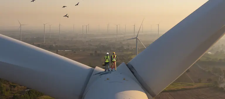 Workers standing on a wind turbine