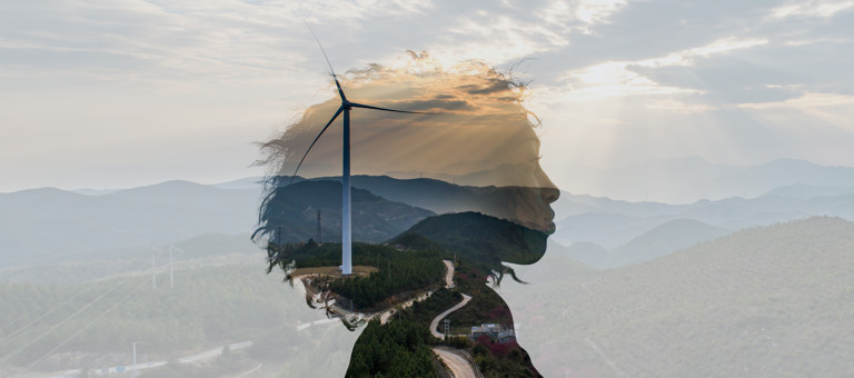 The outline of a woman's head superimposed over mountains and a wind turbine