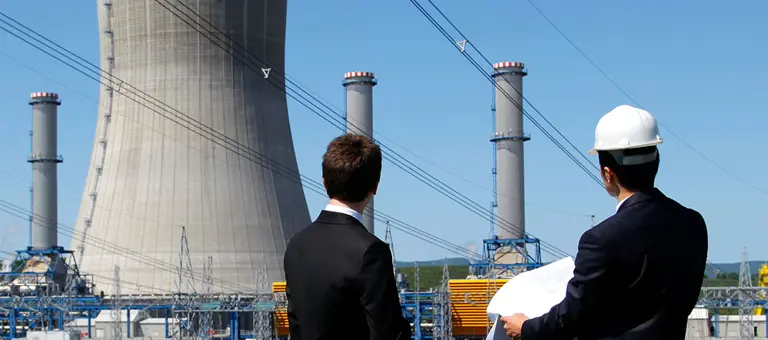 Two people looking towards a nuclear plant