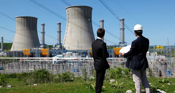 Two people looking towards a nuclear plant