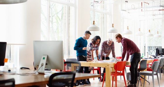 Group of people together at a table in an office