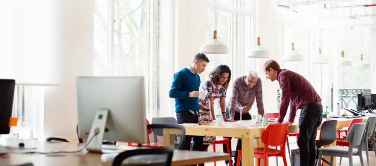 Group of people together at a table in an office