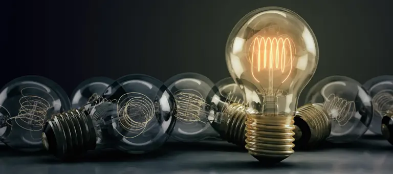 A collection of lightbulbs with one illuminated