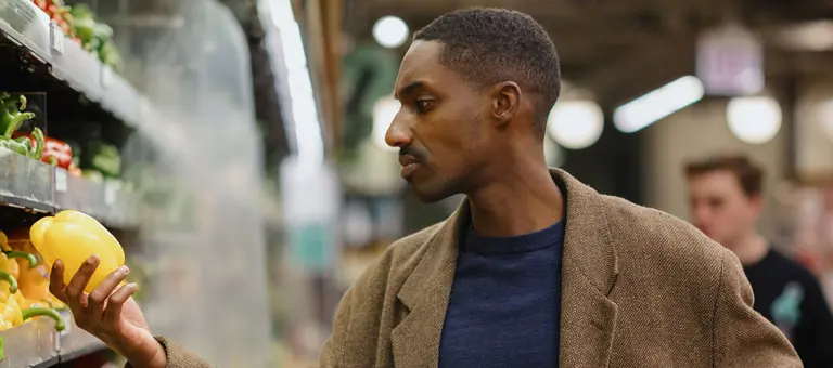 Man Shopping for Fresh Produce in a Supermarket Aisle