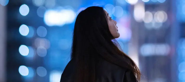 Woman looking up at buildings