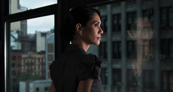 Woman looking over city, reflected in window