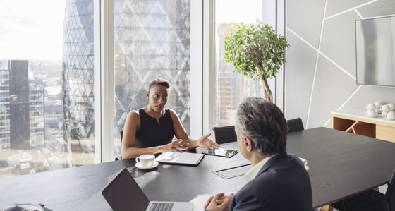 Business man and woman in a conference room with views of London