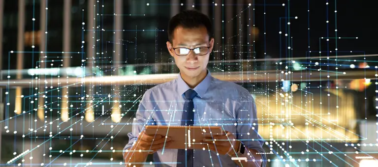 Businessman looking at ipad surrounded by lines representing payments architecture