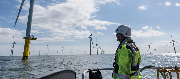 An engineer in a boat approaching an offshore wind farm
