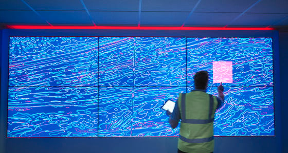 A man pressing a large interactive screen