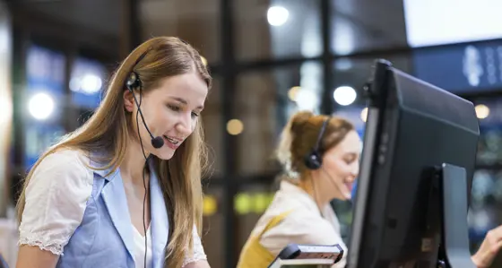 A woman wearing a headset in front of a computer