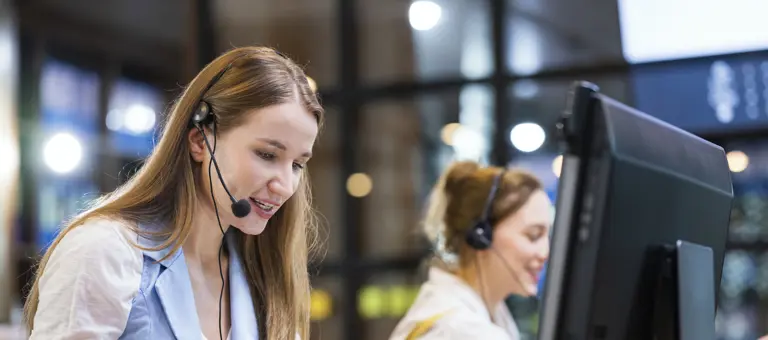 A woman wearing a headset in front of a computer