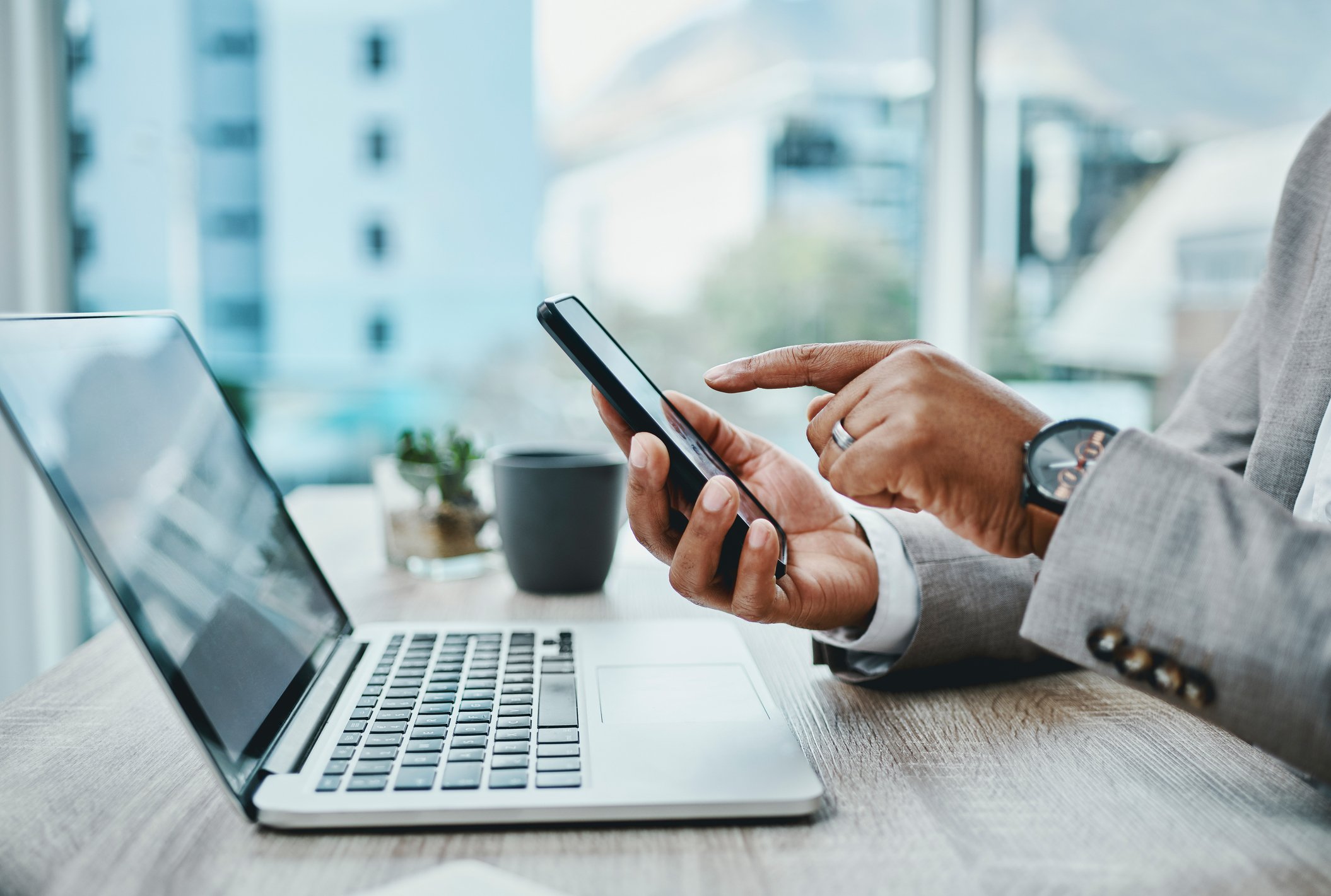 man using phone and laptop