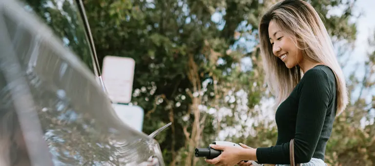 A woman charging her electric car