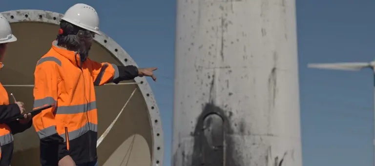 Two people fixing a wind turbine