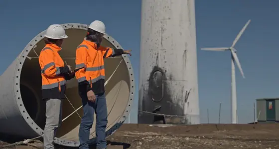 Two people fixing a wind turbine