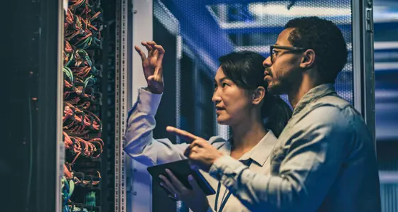 Two IT specialists inspecting a server