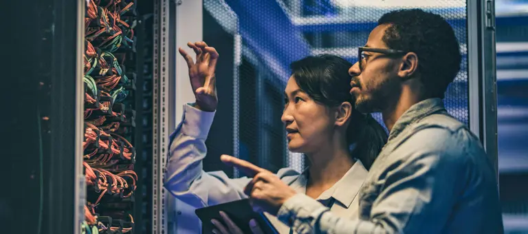 Two IT specialists inspecting a server