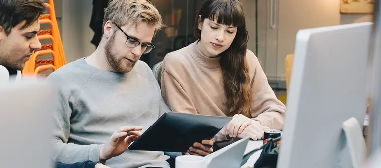 Three colleagues looking at a tablet