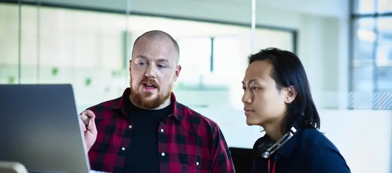Two colleagues looking at a screen and having a discussion