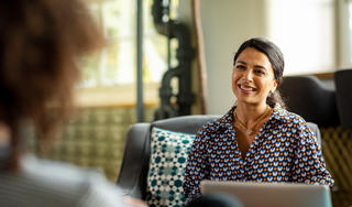 Coworkers having informal meeting in creative office discussing project