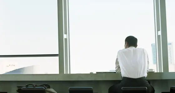 Man sat looking out building window