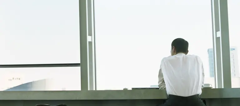 Man sat looking out building window