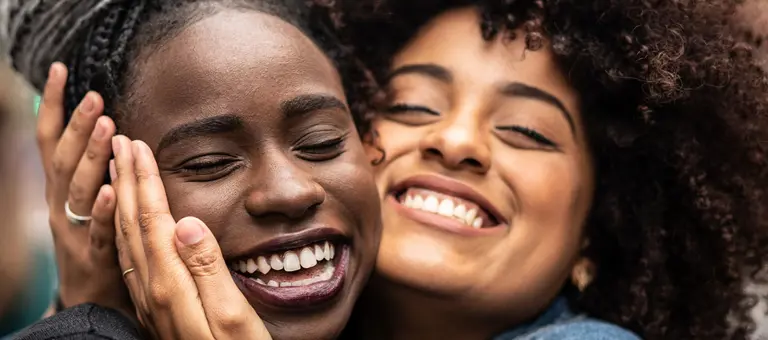 Two girl friends are hugging