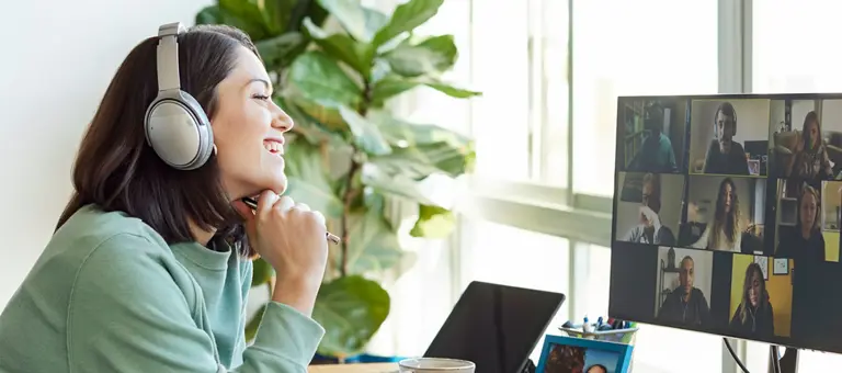 Smiling businesswoman discussing with colleagues through video call