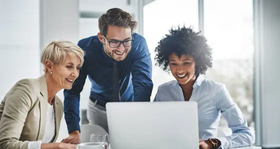 Three people working together on a laptop
